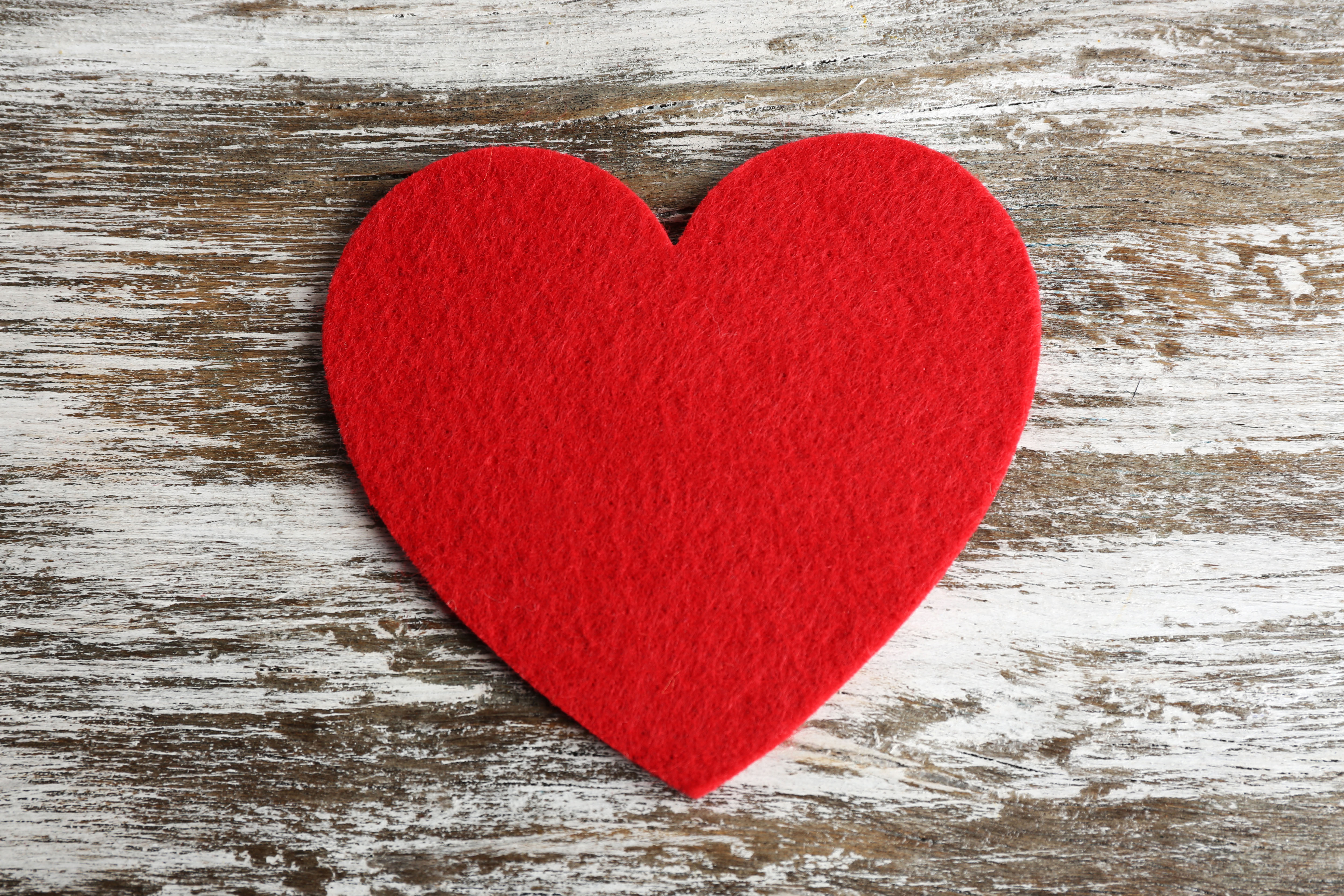 Red felt heart on grey wooden background
